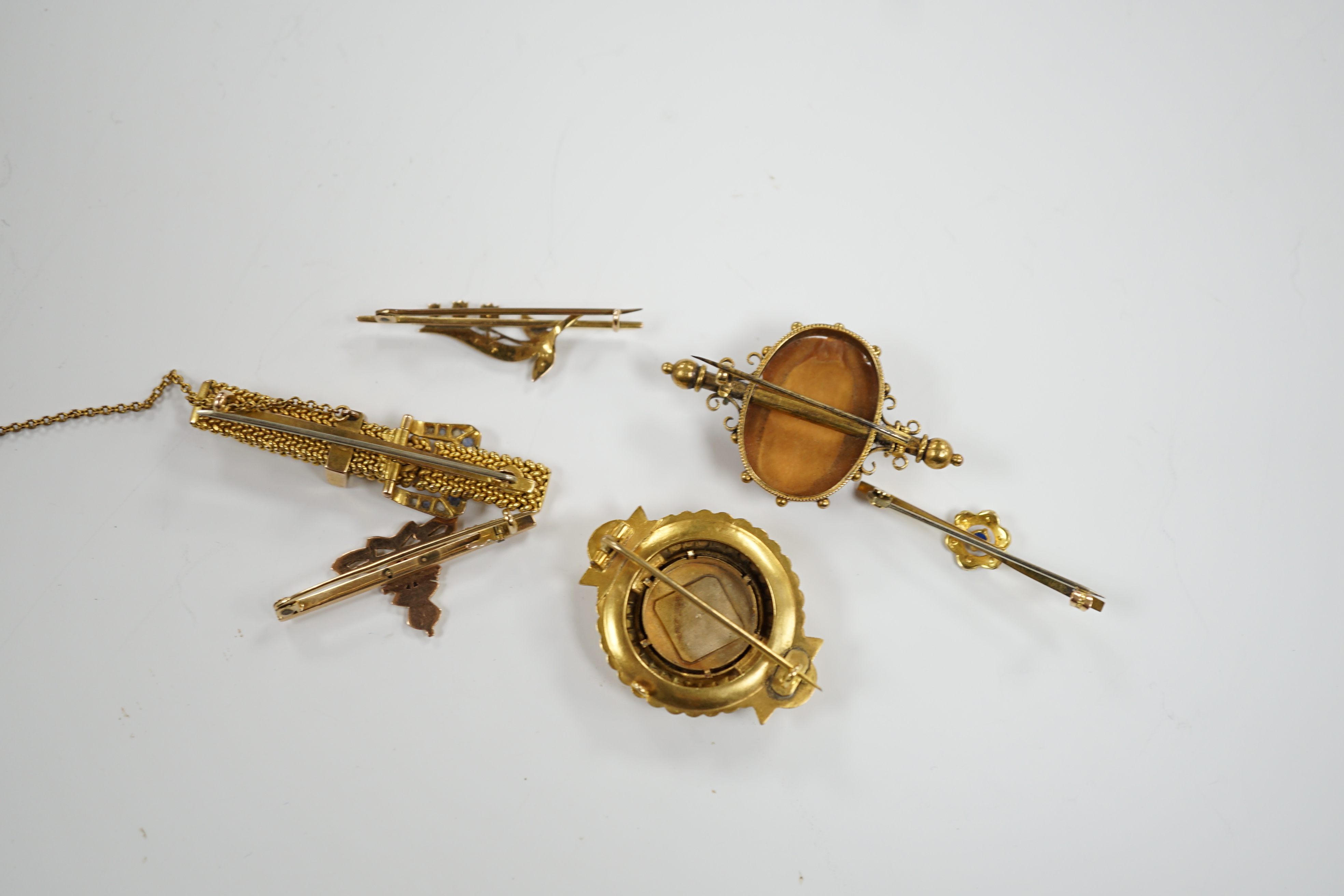 Four assorted yellow metal and gem set bar brooches including sapphire and diamond chip set buckle brooch, 51mm and two other yellow metal brooches, one set with diamond and split pearl
